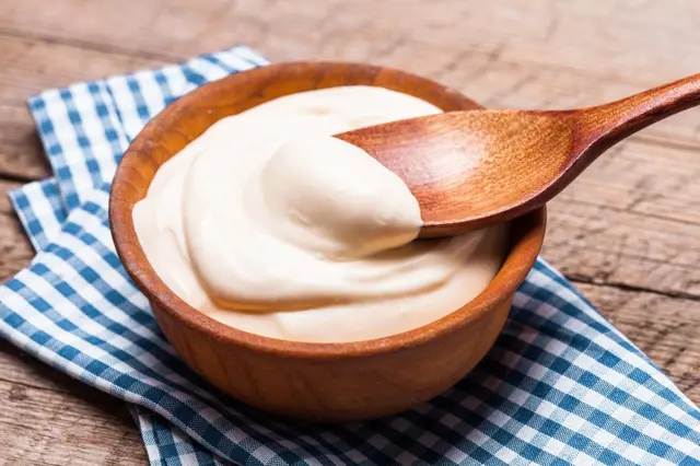 Sour cream in wooden bowl