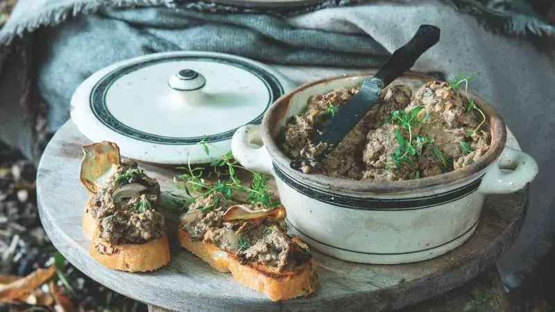 Domácí játrová paštika na toastu s bylinkami.