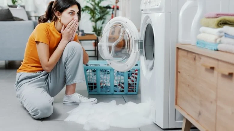 Žena se diví na únik vody z pračky, který může způsobit aquastop.