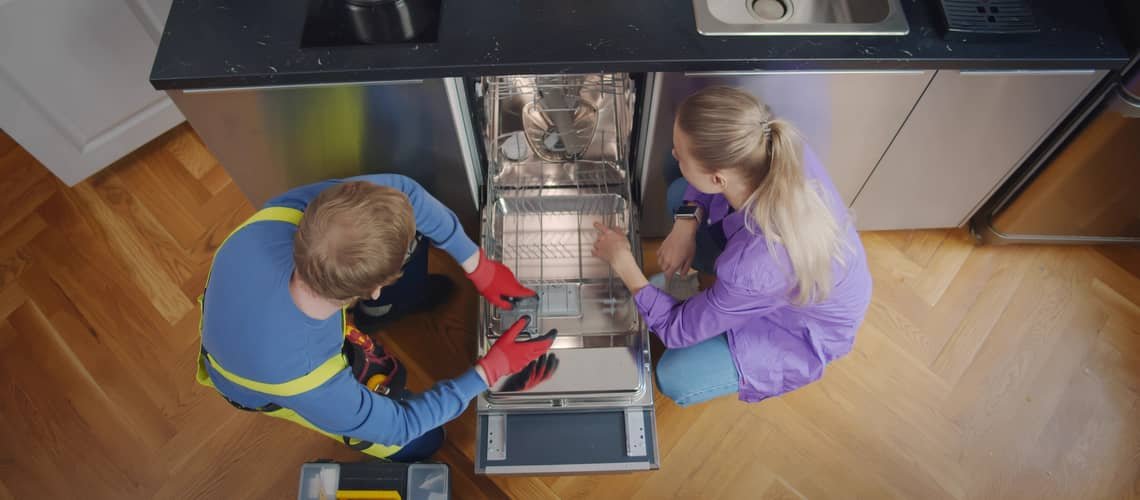 Technik opravuje myčku nádobí s pomocí nástrojů.