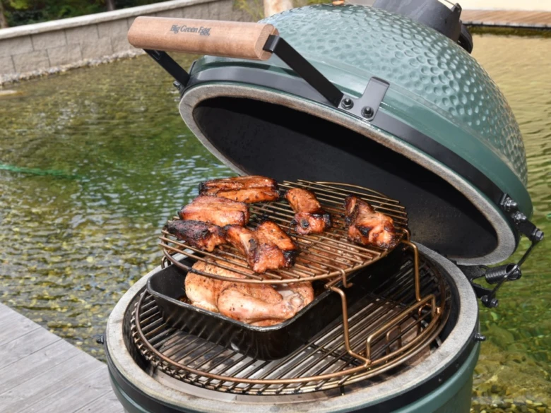 Pečené kuřecí křídla na grilu v zeleném keramickém troubě.