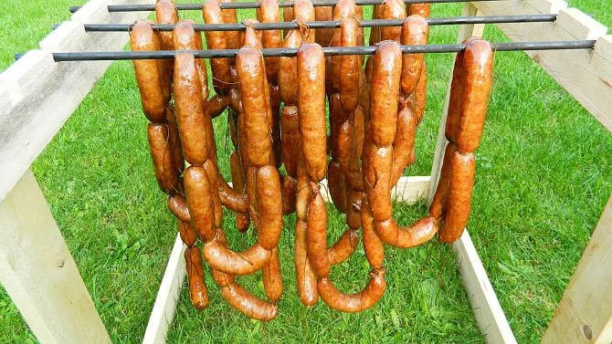 Domácí klobásy visící na rámu venku pro sušení.