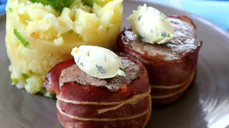 Pork medallions wrapped in bacon served with mashed potatoes.