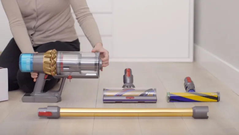 Rozložený vysavač Dyson s příslušenstvím na podlaze.
