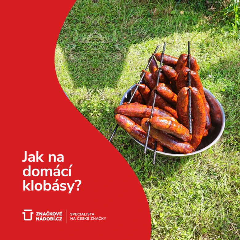 Domácí klobásy grilované v mřížce na trávníku.
