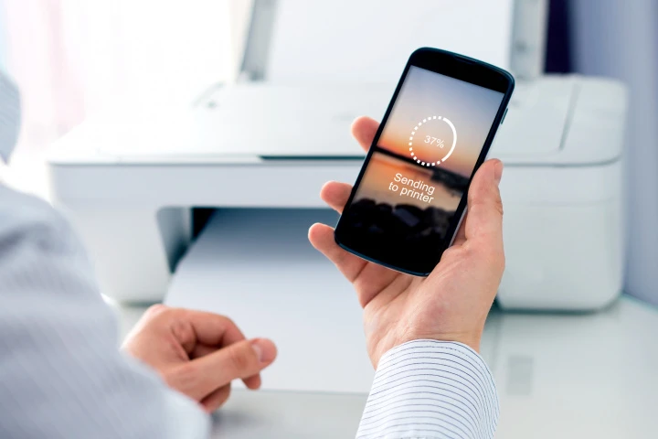 Chytrý telefon odesílá dokument na tiskárnu přes Wi-Fi.