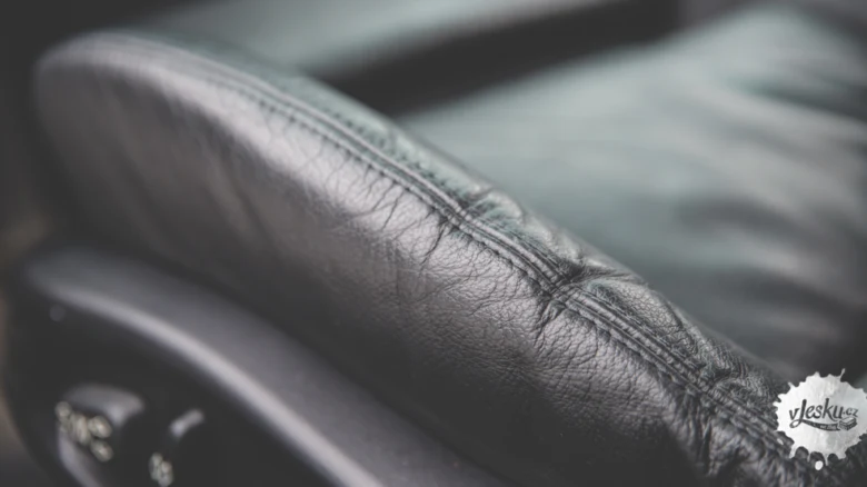 Detailní pohled na černou koženku s viditelnými stehy a texturou.