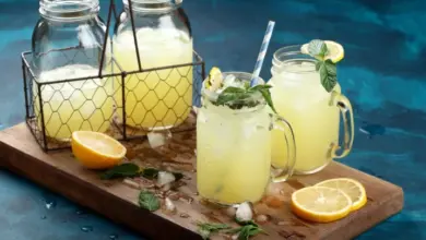 Domácí limonáda s citronem a mátou v džbánku na dřevěném podnose.