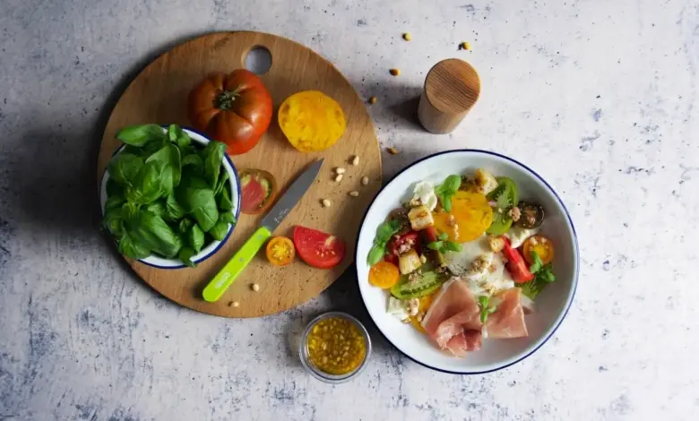 Svěží bazalka s rajčaty a ostatními ingrediencemi pro salát.