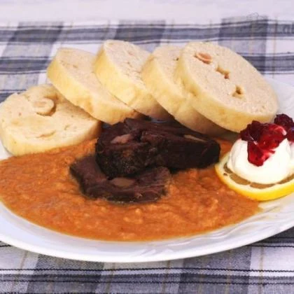 Maso s brusinkovou omáčkou na talíři se zrním chleba.