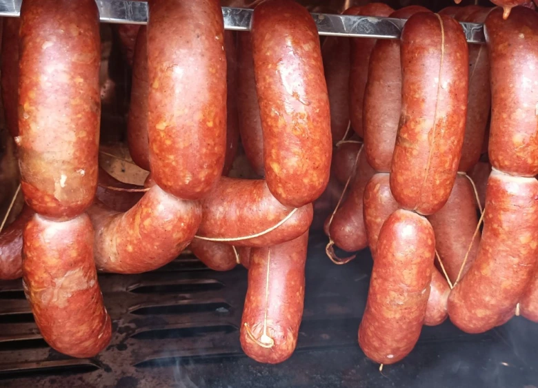 Zavěšené uzené klobásy připravené pro další zpracování nebo zmrazení.