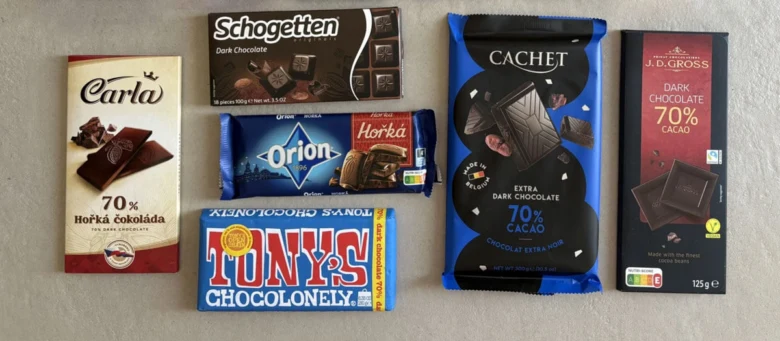 Různé balení horké čokolády od různých značek na neutrálním pozadí.