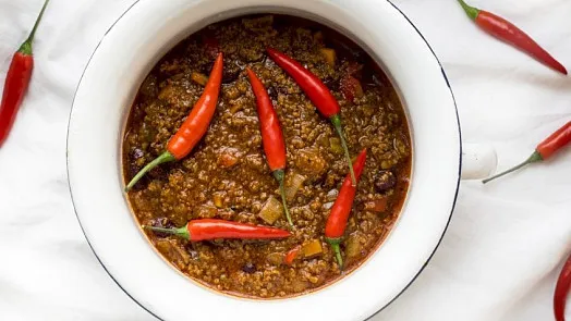 Mísa s masovou omáčkou ozdobená červenými pálivými chilli papričkami.