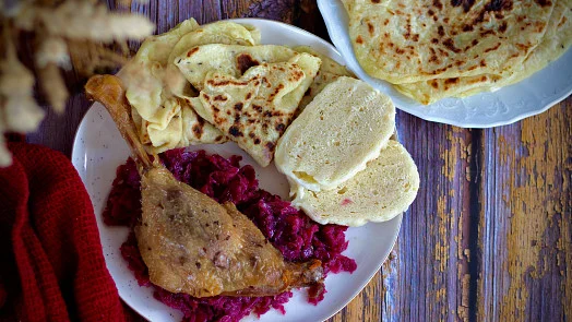 Pekácké kachna s červenou řepou a chlebem na talíři.
