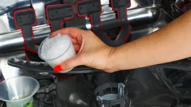 Ruka nalévá prášek do myčky nádobí.