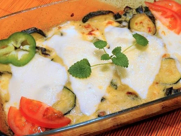 Pečená cuketa s rajčaty, česnekem a bylinkami v keramické formě.