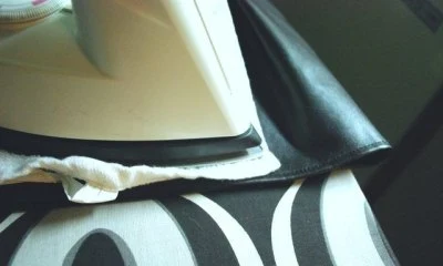 Žehlení kožené bundy s ochrannou utěrkou pod žehličkem.