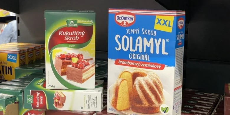Balíčky kukuřičného a bramborového škrobu na polici v obchodě.