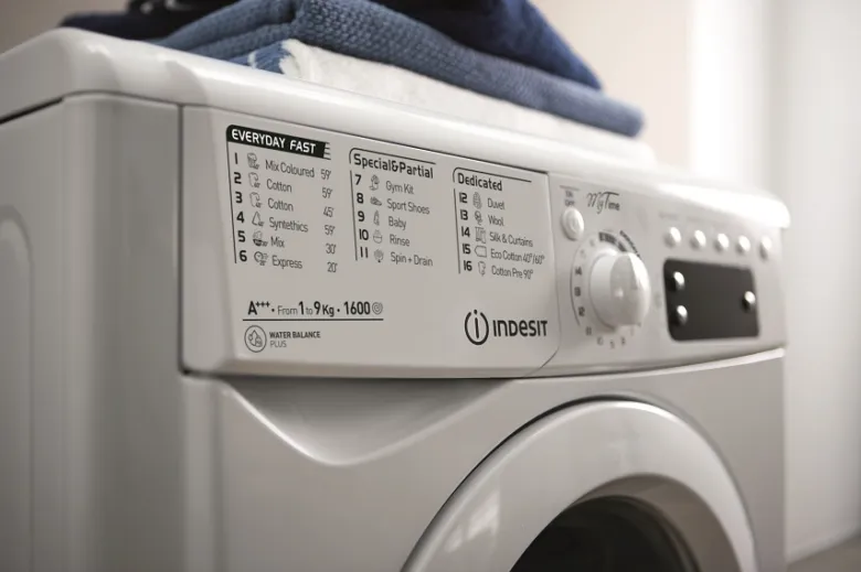 Bílá pračka Indesit s ovládacím panelem a výběrem programu.