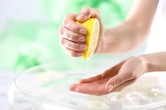 ruka vymačká citron do dlaně nad mýdlovou směsí