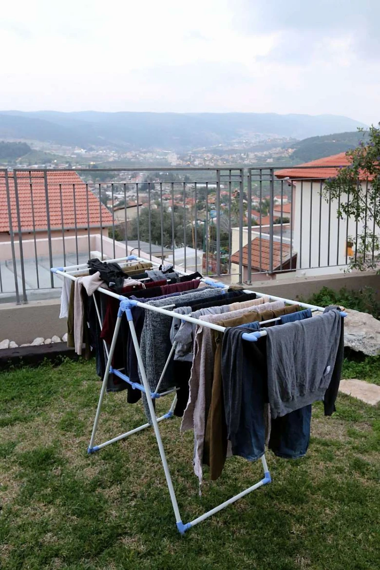 Domácí sušička prádla na balkóně s oblečením vysoušejícím se venku.