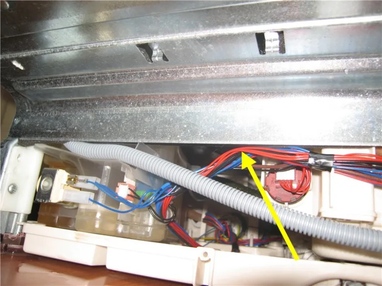 Vnitřní elektrické spoje myčky s označeným vodičem pro diagnostiku chyby.