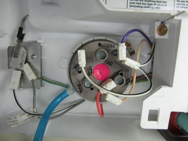 Vnitřní elektrické spoje motora pračky s připojenými kabely.