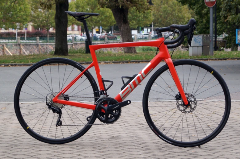 Červená silniční bicykl značky EML s kotoučovými brzdy.