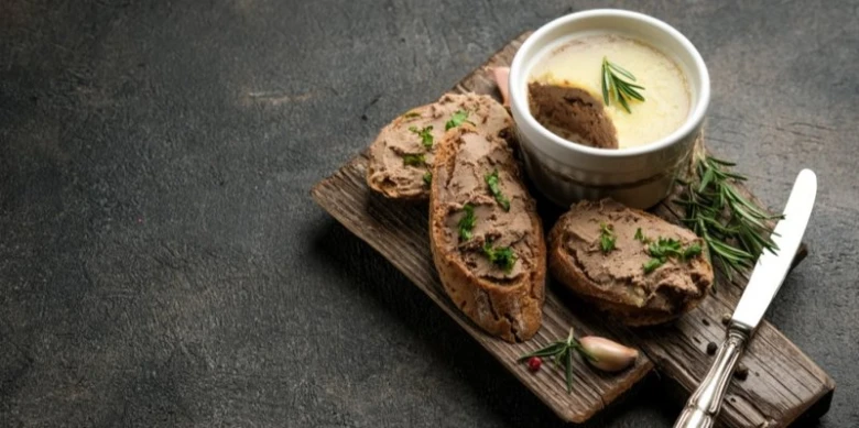 Krůtí játra v paté s chlebem a čerstvou bylinkou.