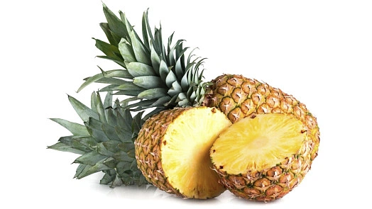 Čerstvý ananas s listy a dvěma nakrájenými polovinami na bílém pozadí.