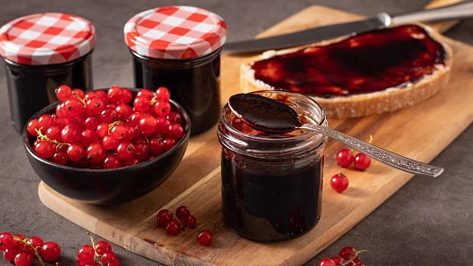 Sklenice s marmeládou z rybízu a čerstvé červené rybičky.