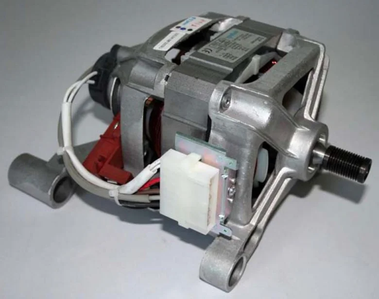 Otevřený elektromotor pračky s viditelnými součástkami a kabely.