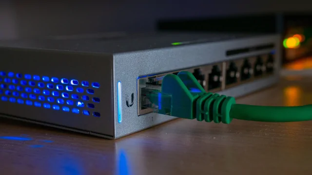Zelený síťový kabel připojený k aktivnímu síťovému komutátoru.