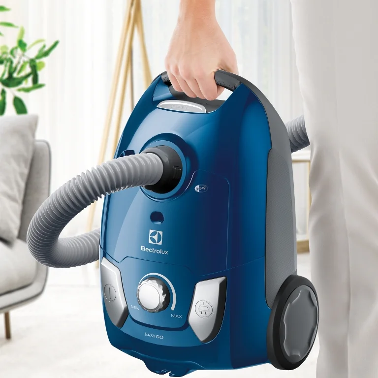 Modrý vysavač značky Electrolux držený v ruce.