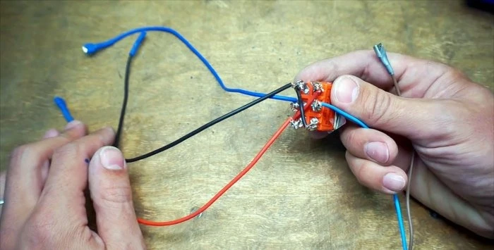 Ruční připojení vodičů k elektromotoru pračky.