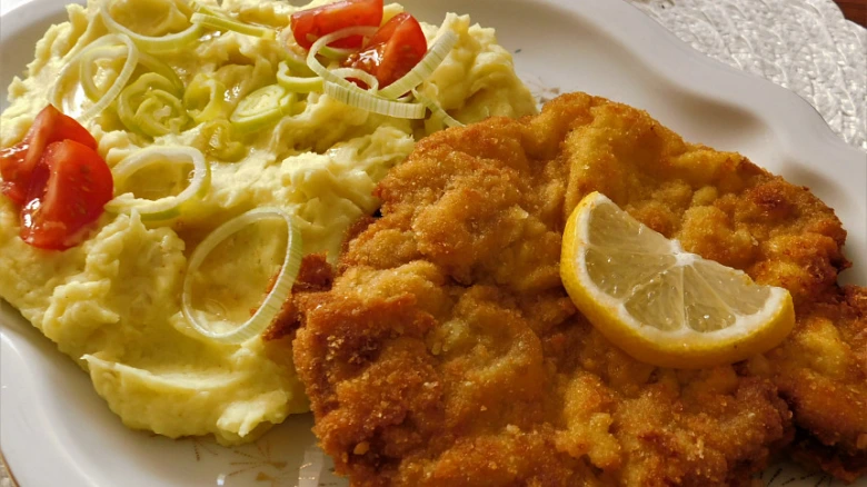 Zlatohnědý kuřecí řízek s citronem a bramborovou kaší.