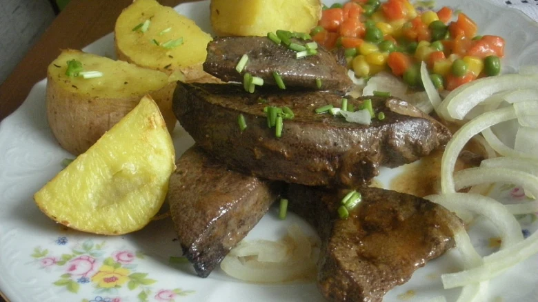 Uvařená játra s bramborami a zeleninou na talíři.
