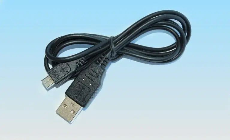 Černý USB kabel pro přenos souborů mezi počítačem a notebookem.