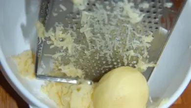 Strouhání syrové brambory na struhadle do misky.