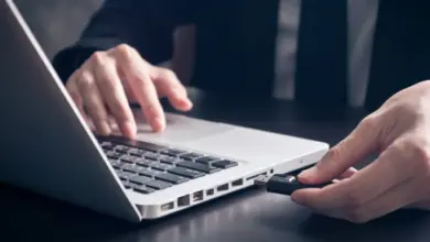 Ruka vkládá USB disk do počítače pro přenos dat.
