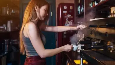 Baristka připravuje espressa v kávovaru s tlakem.