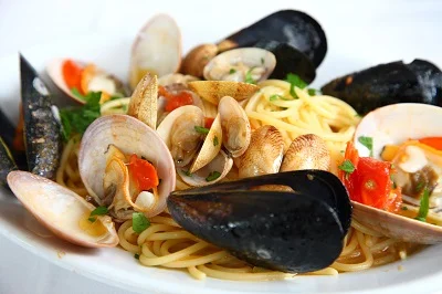 Pasta s uvařenými mušlemi a krevetkami v omáčce.