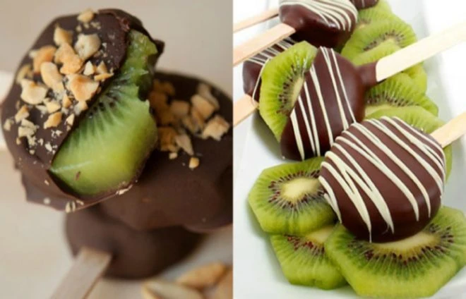 Mražené kousky kiwi obalené čokoládou na tyčinkách.