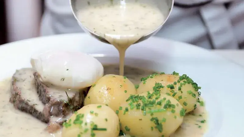 Křemenná omáčka se nalévá na maso s vejcem a bramborami.