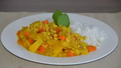 Sójové boby v kari s rýží a zeleninou na talíři.