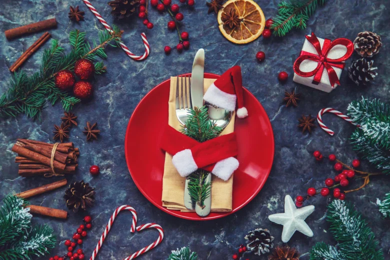 Vánoční stůl s ubrouskem zdobeným jehličím a Santa čepicí