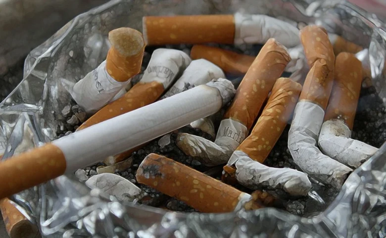 Použité cigarety v popelu na podložce.