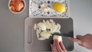 Recept na citron s česnekem: sekaná cibule, stroužky česneku a celý citrón.