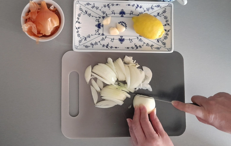 Recept na citron s česnekem: sekaná cibule, stroužky česneku a celý citrón.