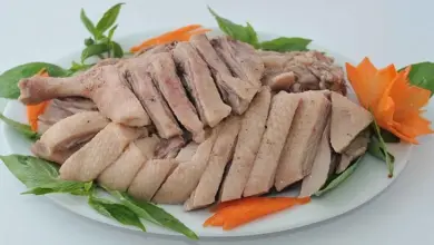 Použitá kachní maso na bílém talíři s ozdobami.
